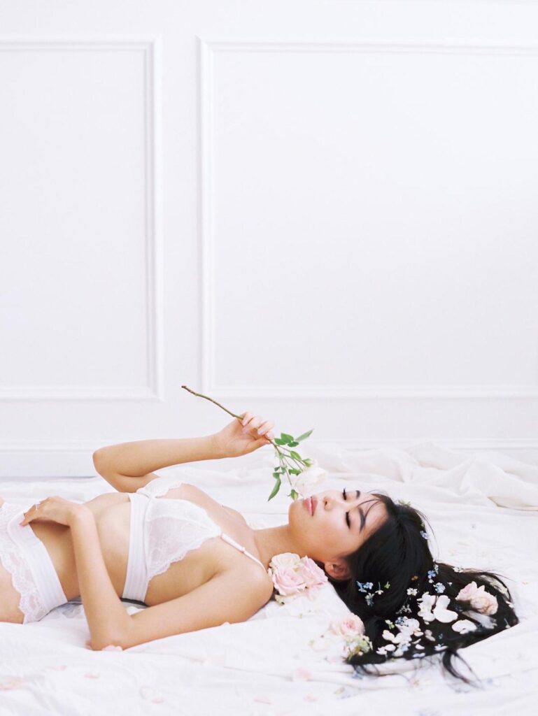 asian woman laying on the floor wearing white lacy lingerie