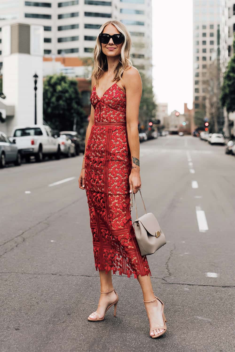 image of a woman wearing a lace detail red midi dress and nude heels