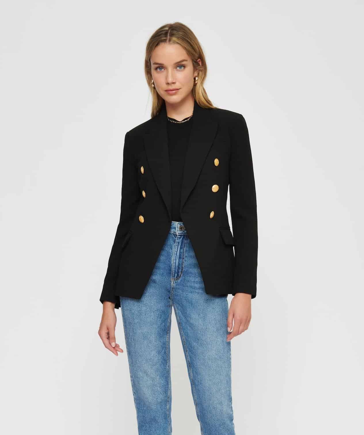 image of a woman wearing a black blazer with gold buttons and blue jeans