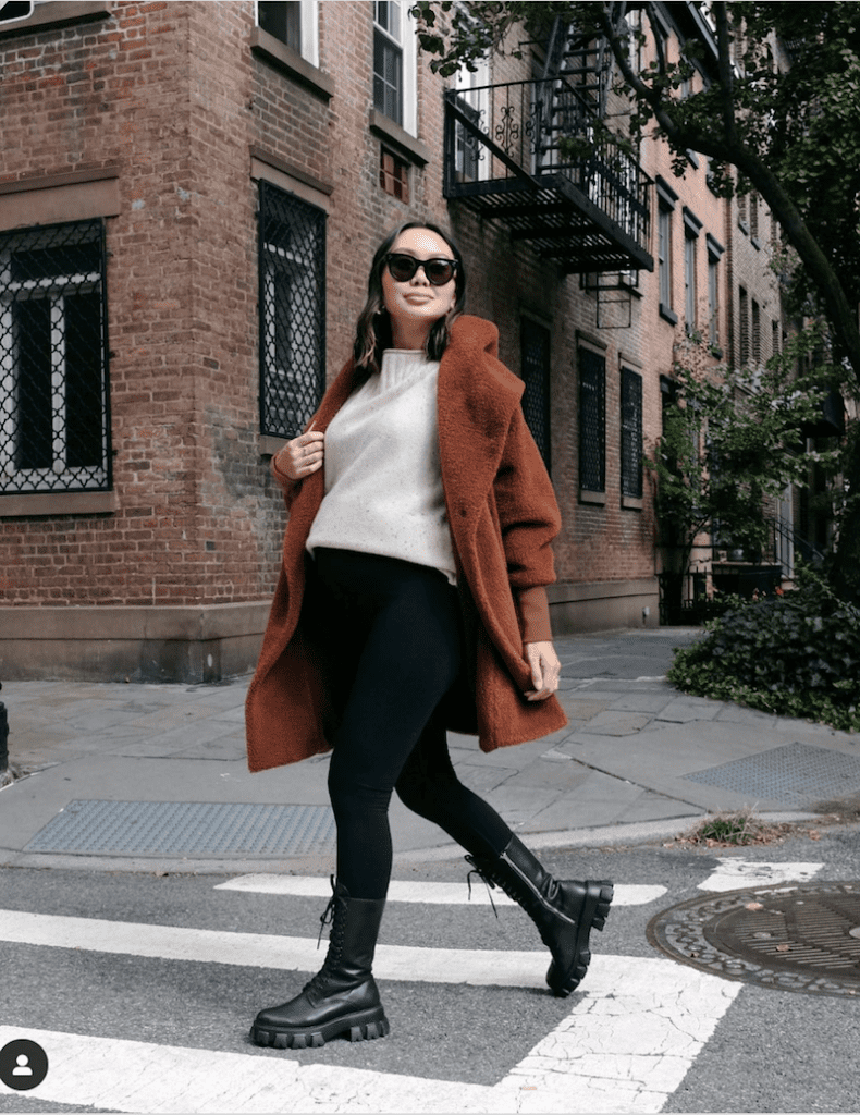 image of a pregnant woman crossing the street wearing a fashionable fall outfit