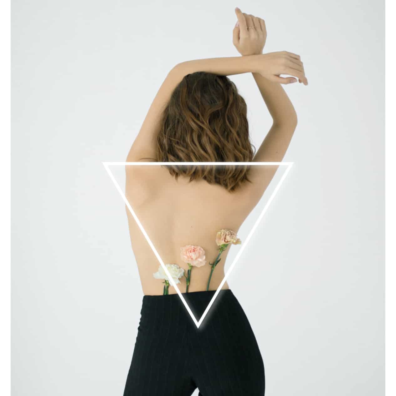 Young woman standing backwards with an upside down triangle drawn on her back to represent broad shoulders. 