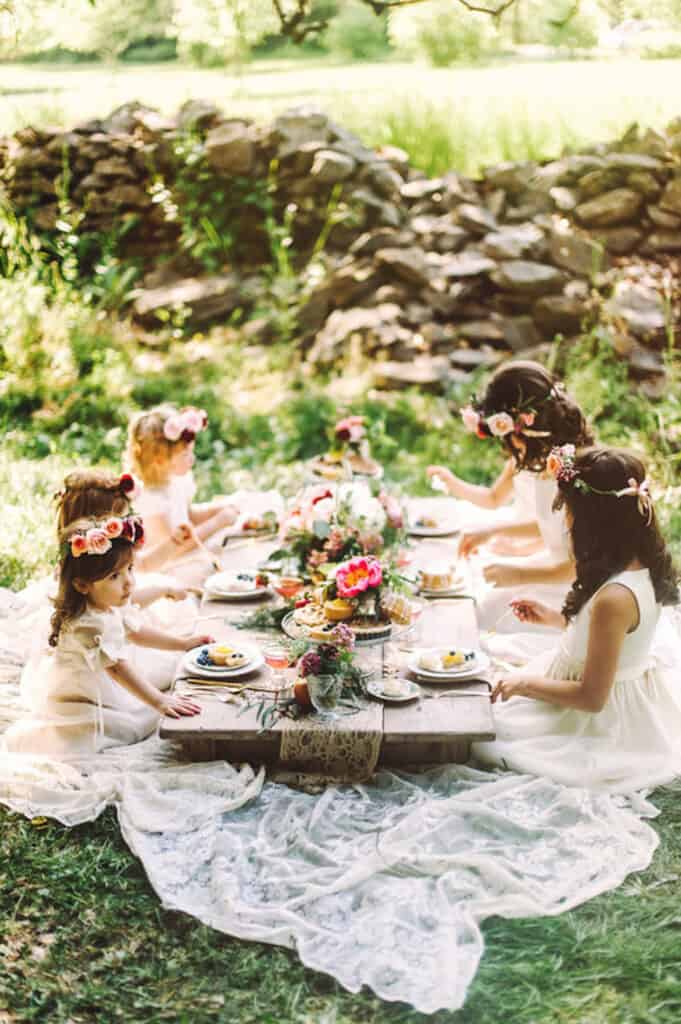 image of small girls having a garden party around a table in a green space