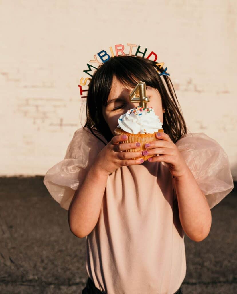 an image of a small girl eating a birthday cupcake