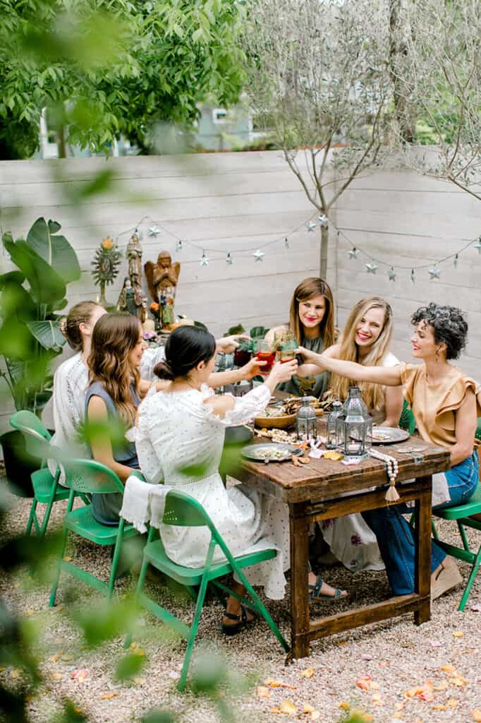 an image of a group of women having a cheers at a table in a backyard