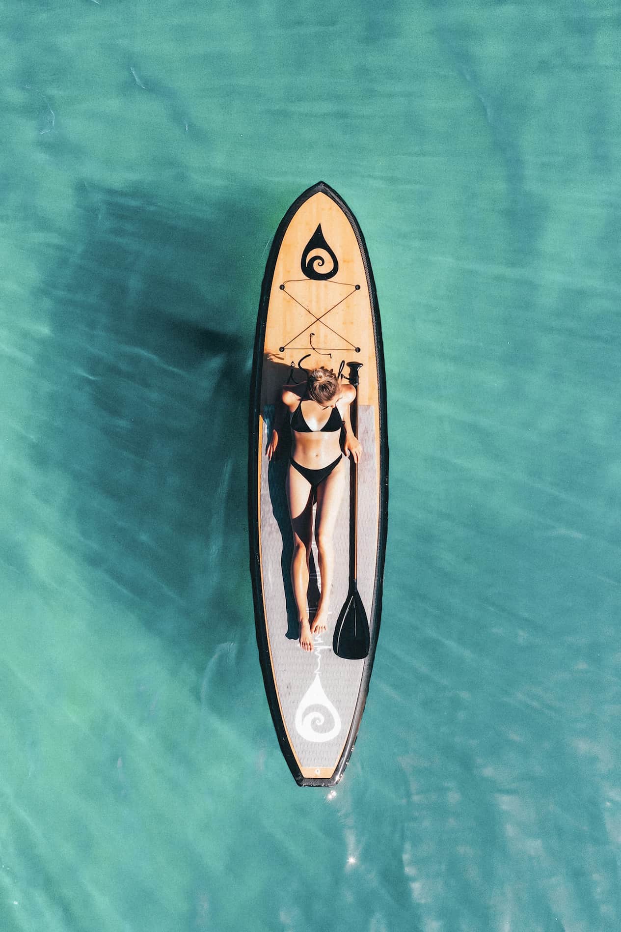 Woman wearing a black bikini on a paddle board