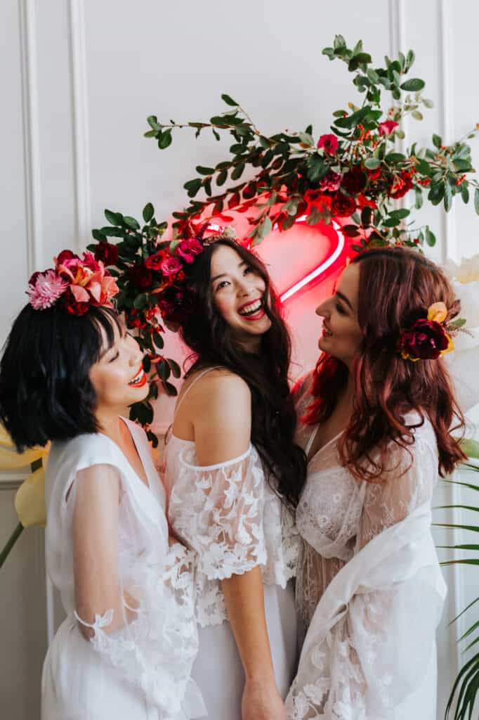 an image of three women wearing white dresses with flower crowns on their heads