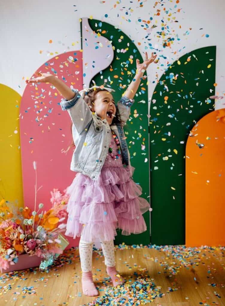 an image of a young girl throwing confetti in the air