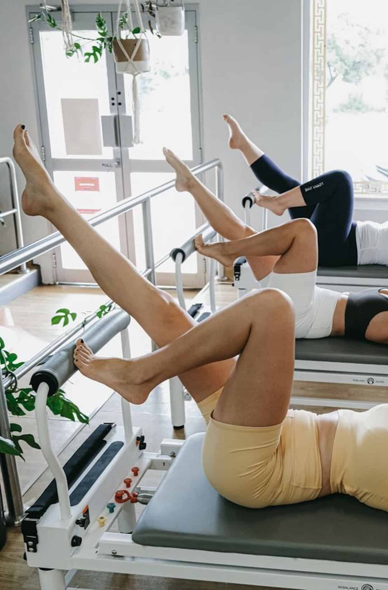 Women on reformer pilates machines.