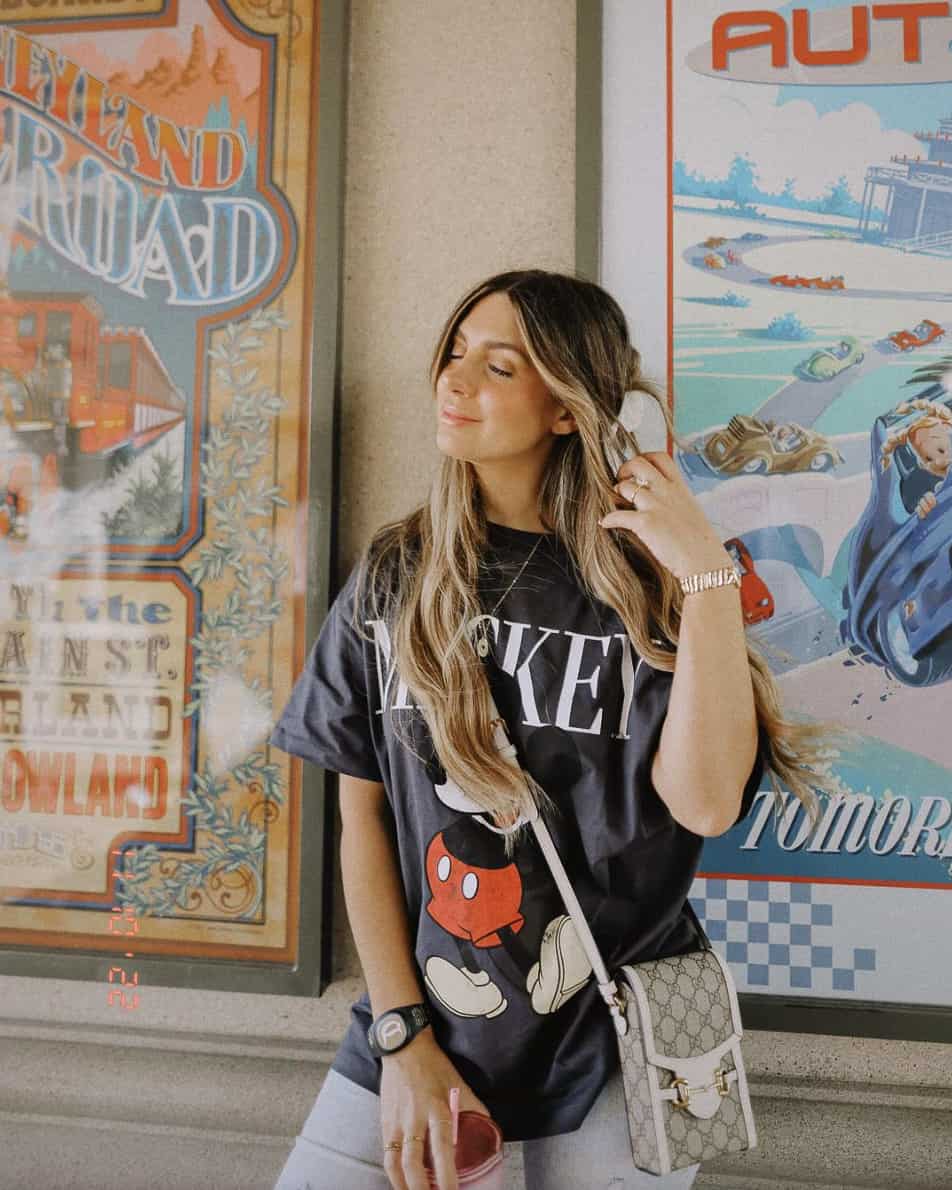 Woman wearing a Mickey Mouse black t-shirt with a Gucci bag at Disney World