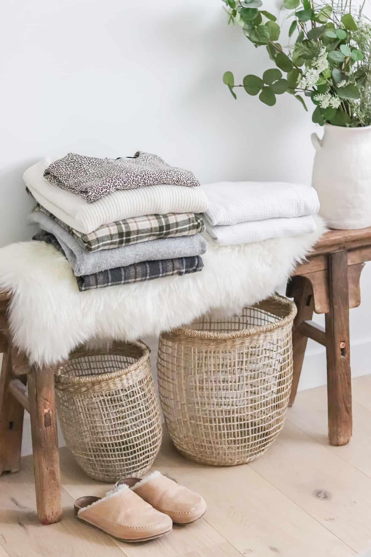 Clothing and slippers stacked on a wooden bench and faux fur.