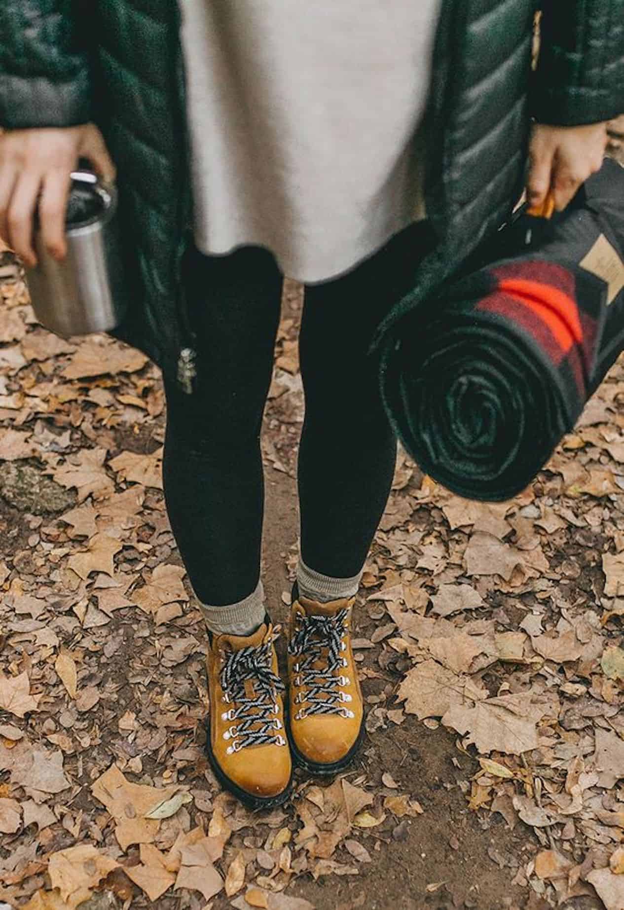 Girl wearing black leggings, hiking boots, and a black puffer jacket.