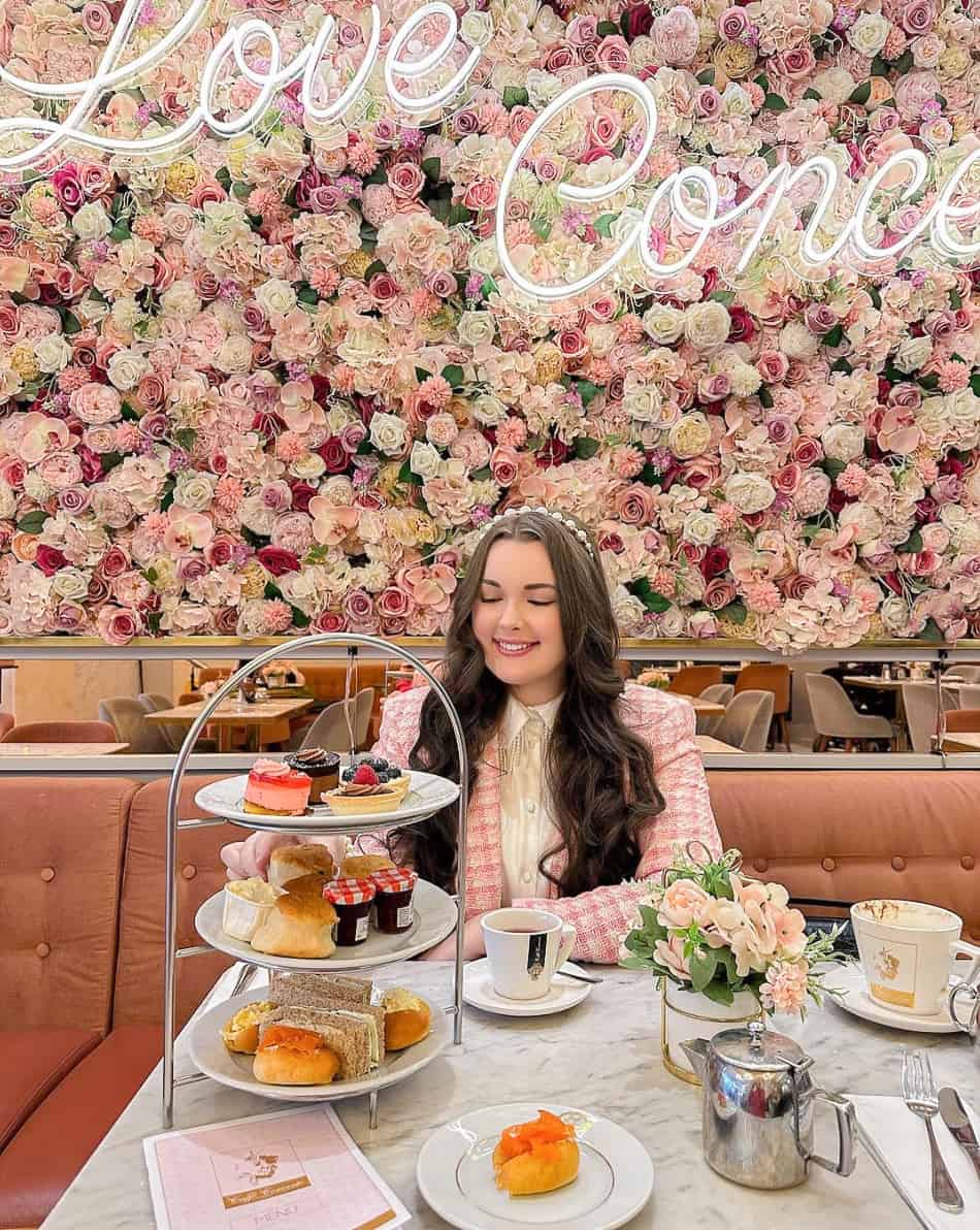 image of a woman at High tea wearing a pink tweed jacket and pearl headband