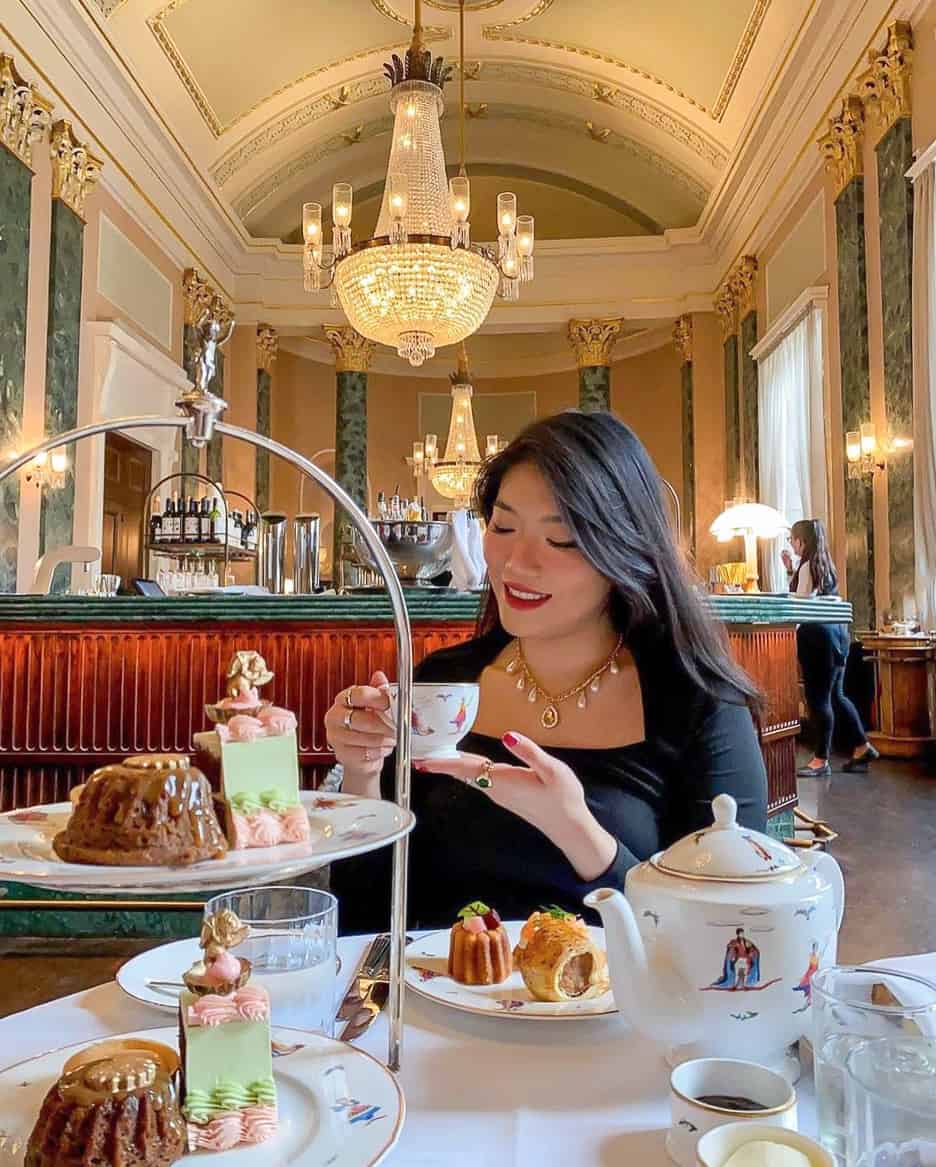 image of a woman at a high tea wearing a black dress and fancy necklace