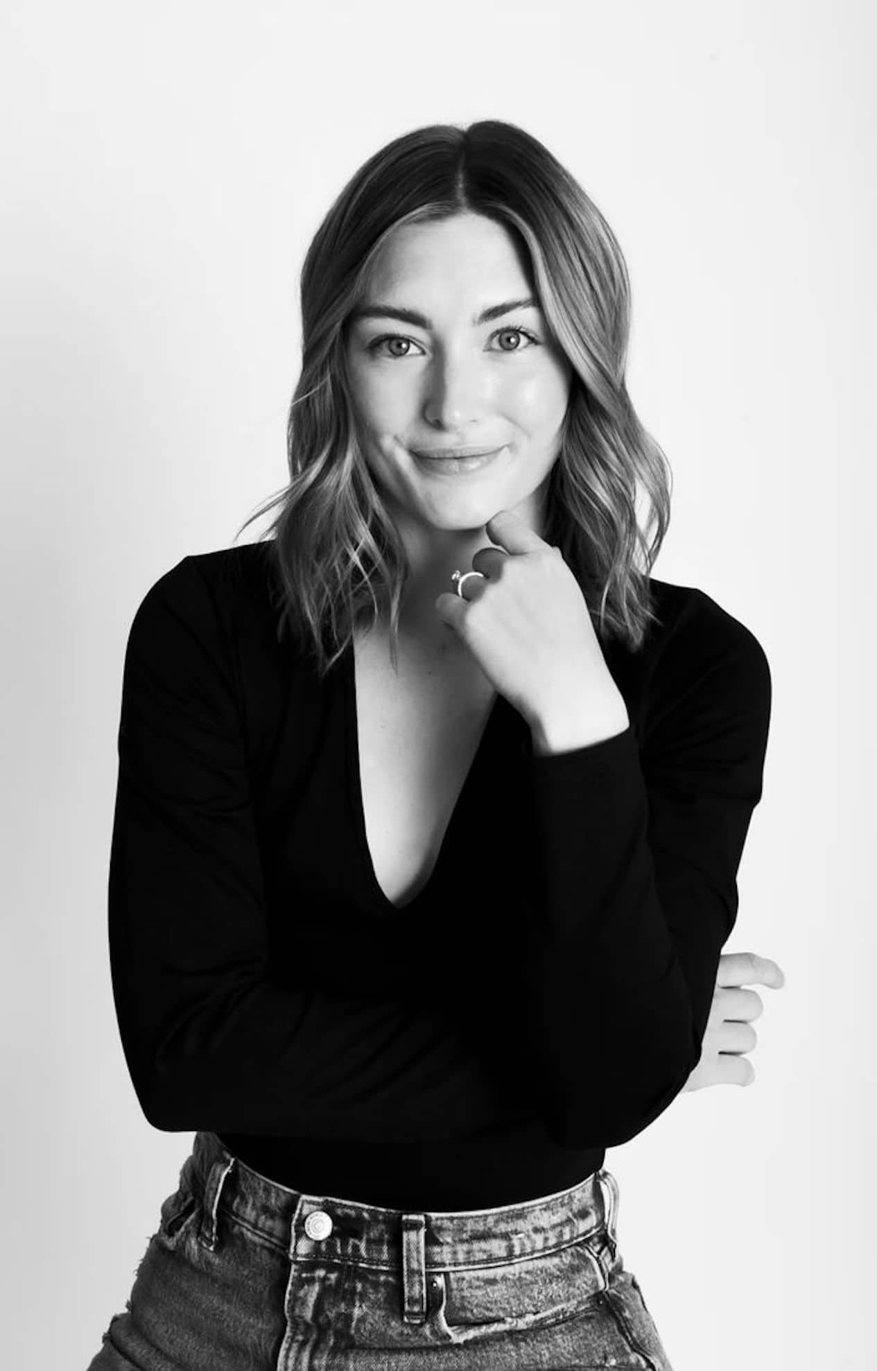 Black and white headshot of a woman smiling without showing her teeth.