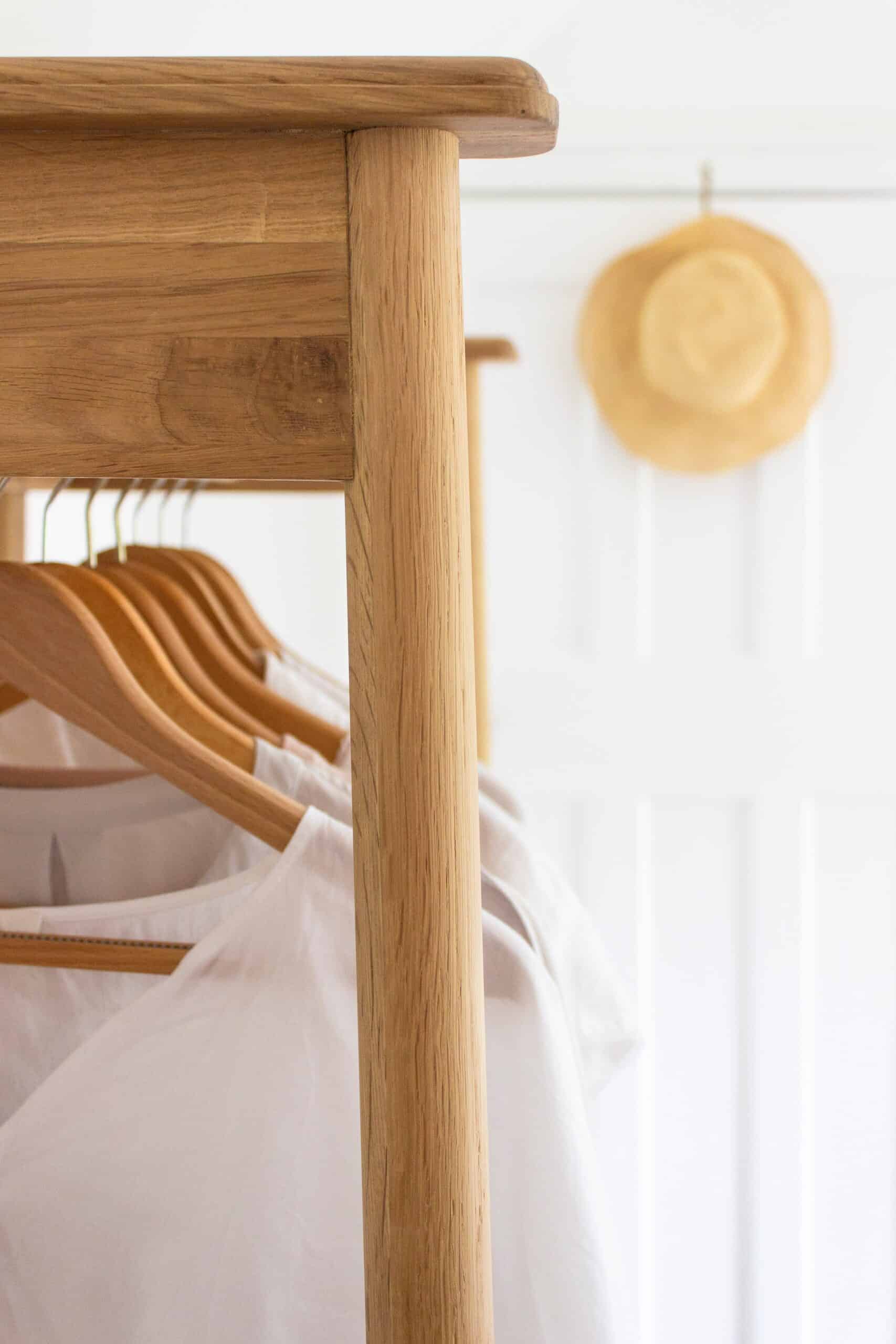 Linen shirts hanging from a wooden clothing rack.