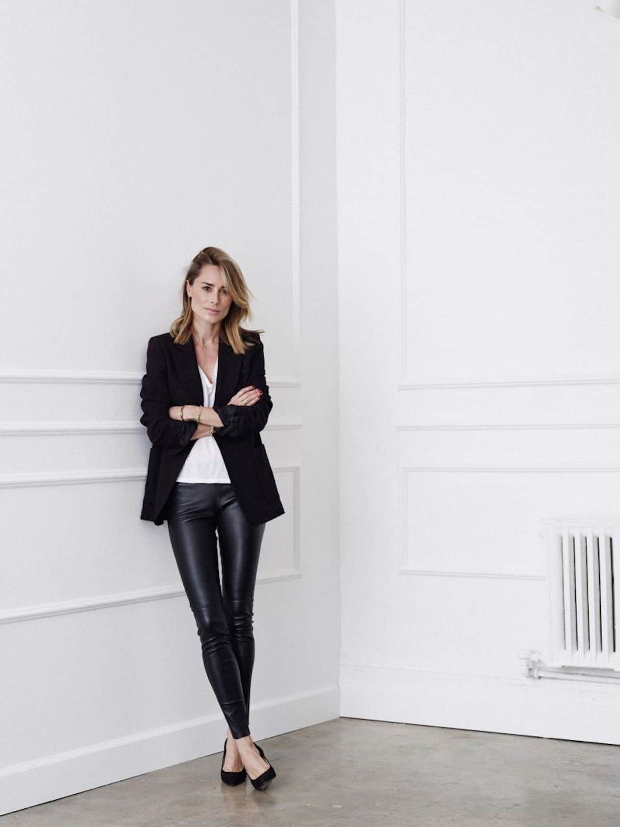 Woman wearing black leather leggings and a black blazer.