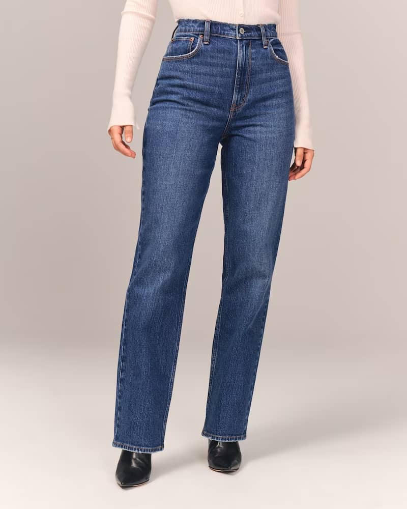 mid-size woman wearing curvy straight leg blue jeans with black boots