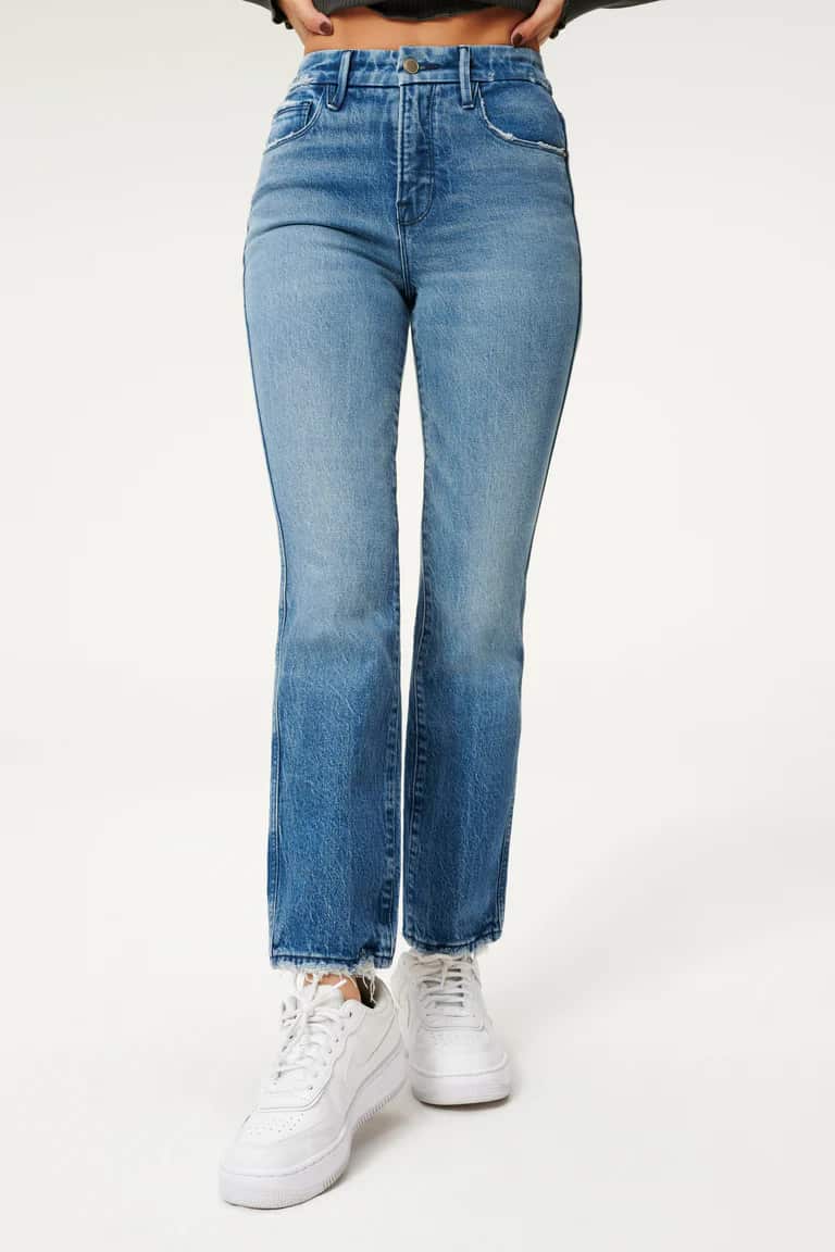 mid-size woman wearing curvy straight leg blue jeans with white sneakers
