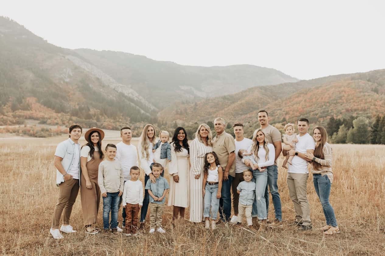 image of a very large family photo outside in a mountain area with everyone in neutral color tones