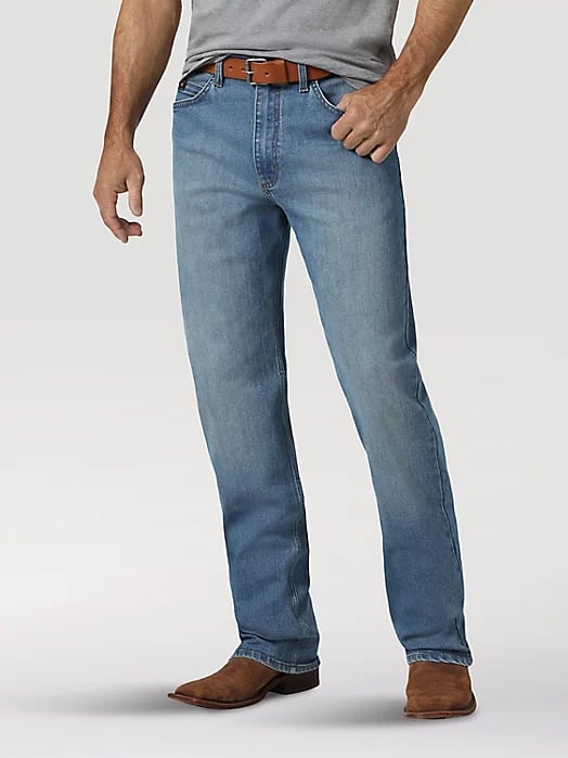 image of a man from the waist down wearing a grey shirt, brown belt, blue bootcut jeans, and brown cowboy boots
