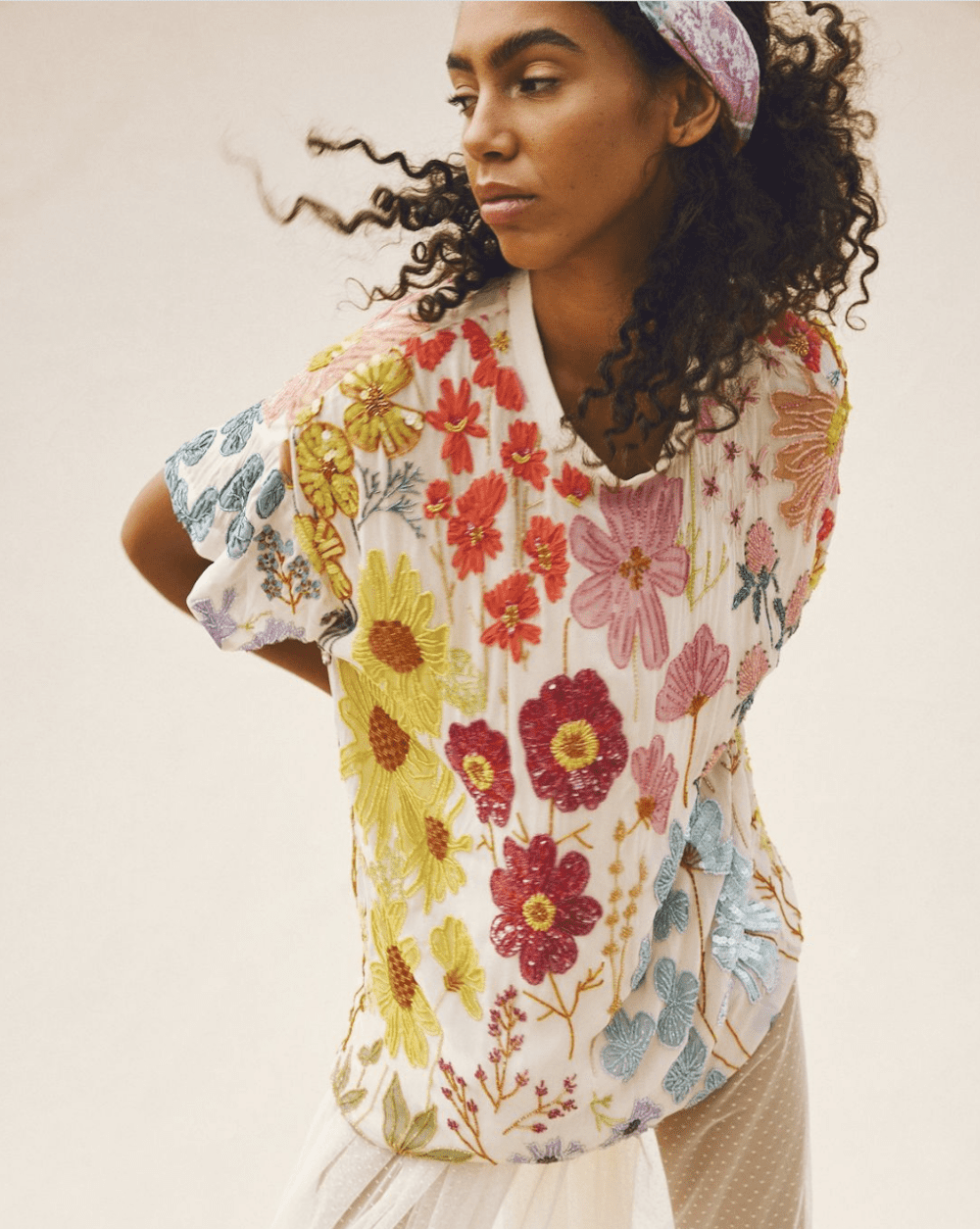 image of a black woman in a floral t-shirt and a colourful headband