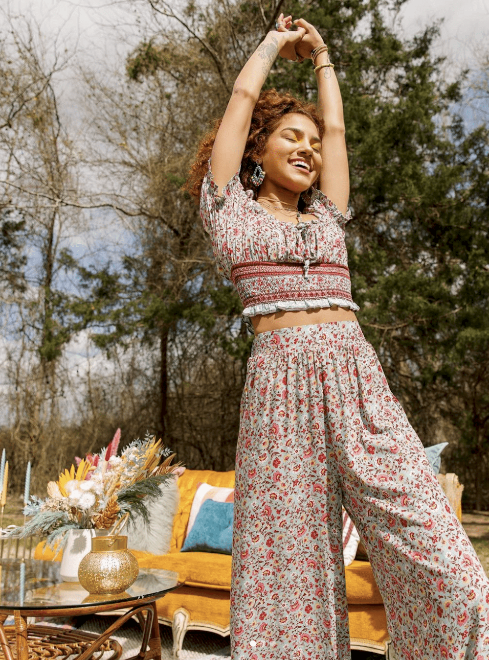 image of a woman in a floral top and pants set in a boho setting