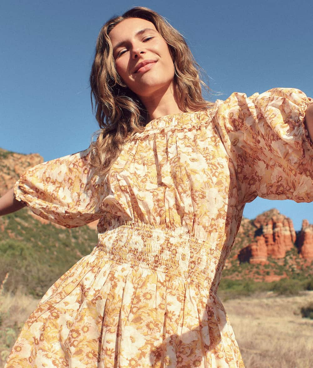 image of a woman I'm a bohemian style yellow floral dress