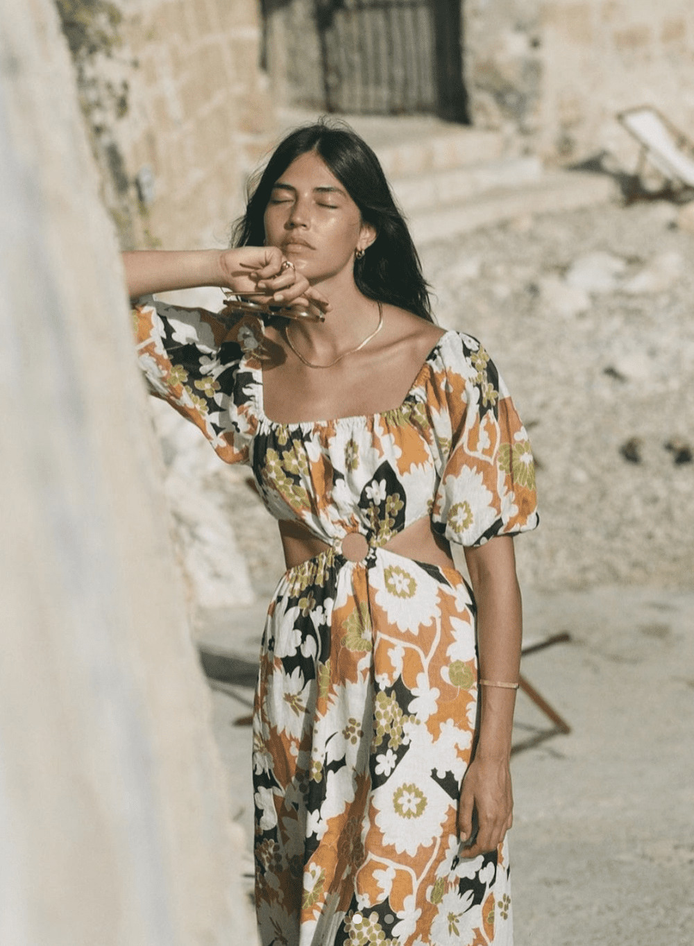 image of a woman with a floral brown, green, and white dress on