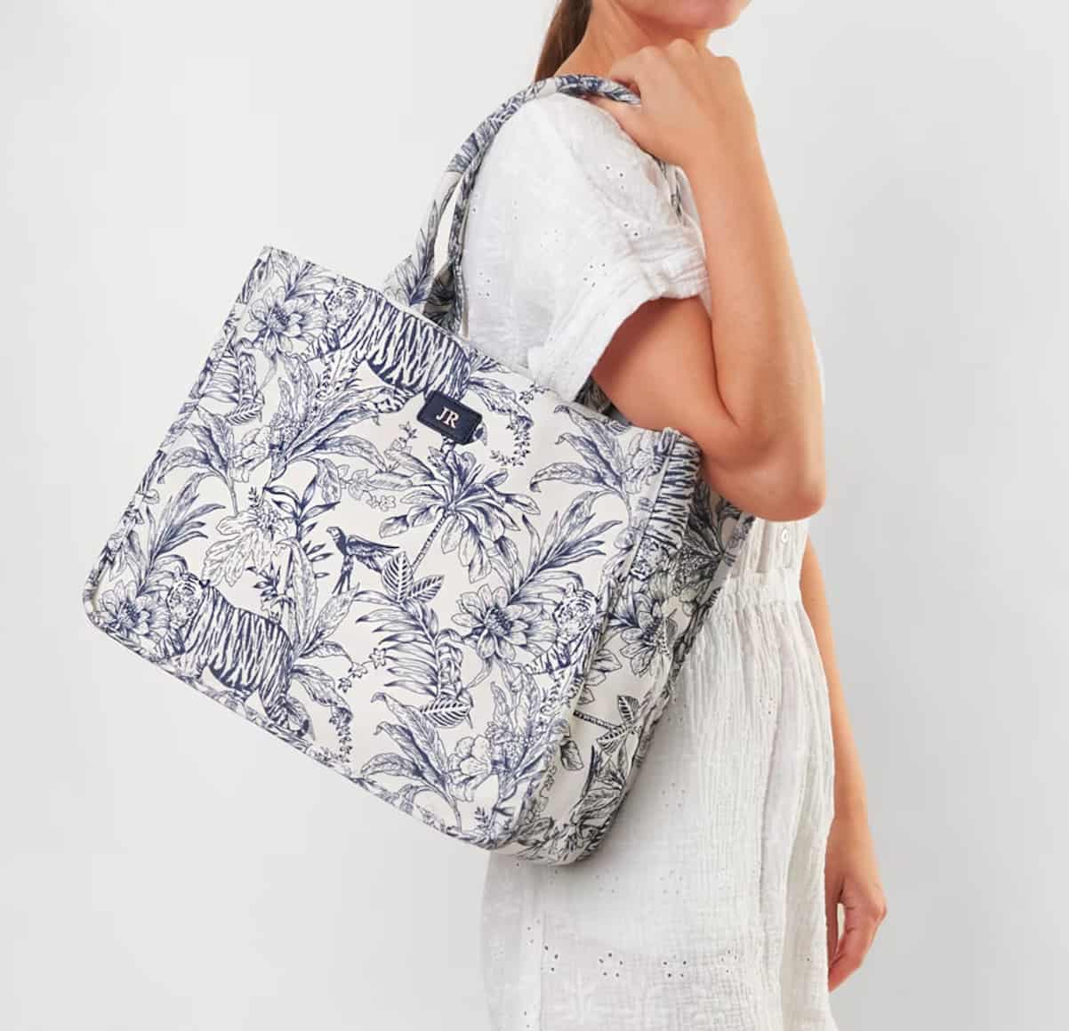 woman wearing an embroidered canvas tote with blue toile details