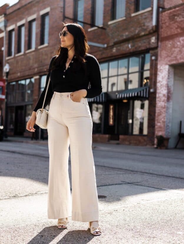 Image of a woman wearing white wide leg jeans and a black bodysuit.