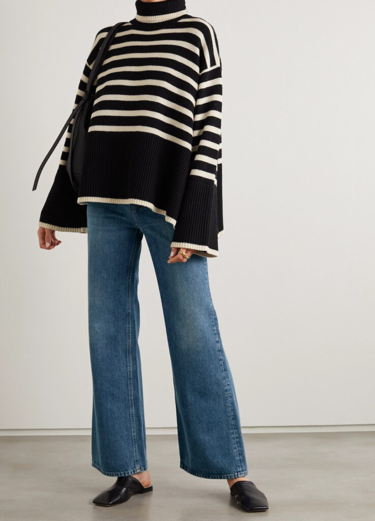 image of a woman in an oversized striped sweater and wide leg jeans