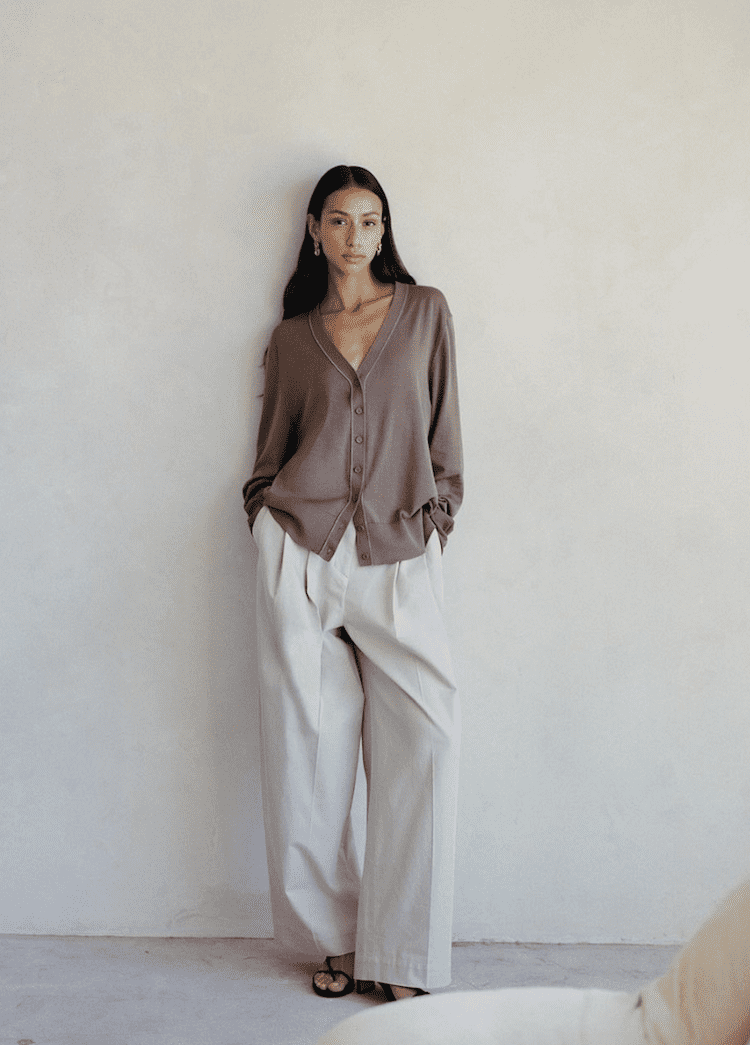 image of a woman wearing a taupe cardigan and loose ivory trousers