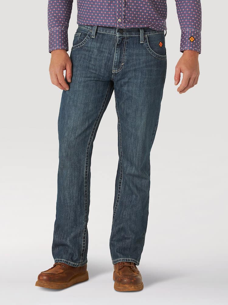 image of a man from the waist down wearing a plaid button up shirt, bootcut jeans, and brown shoes