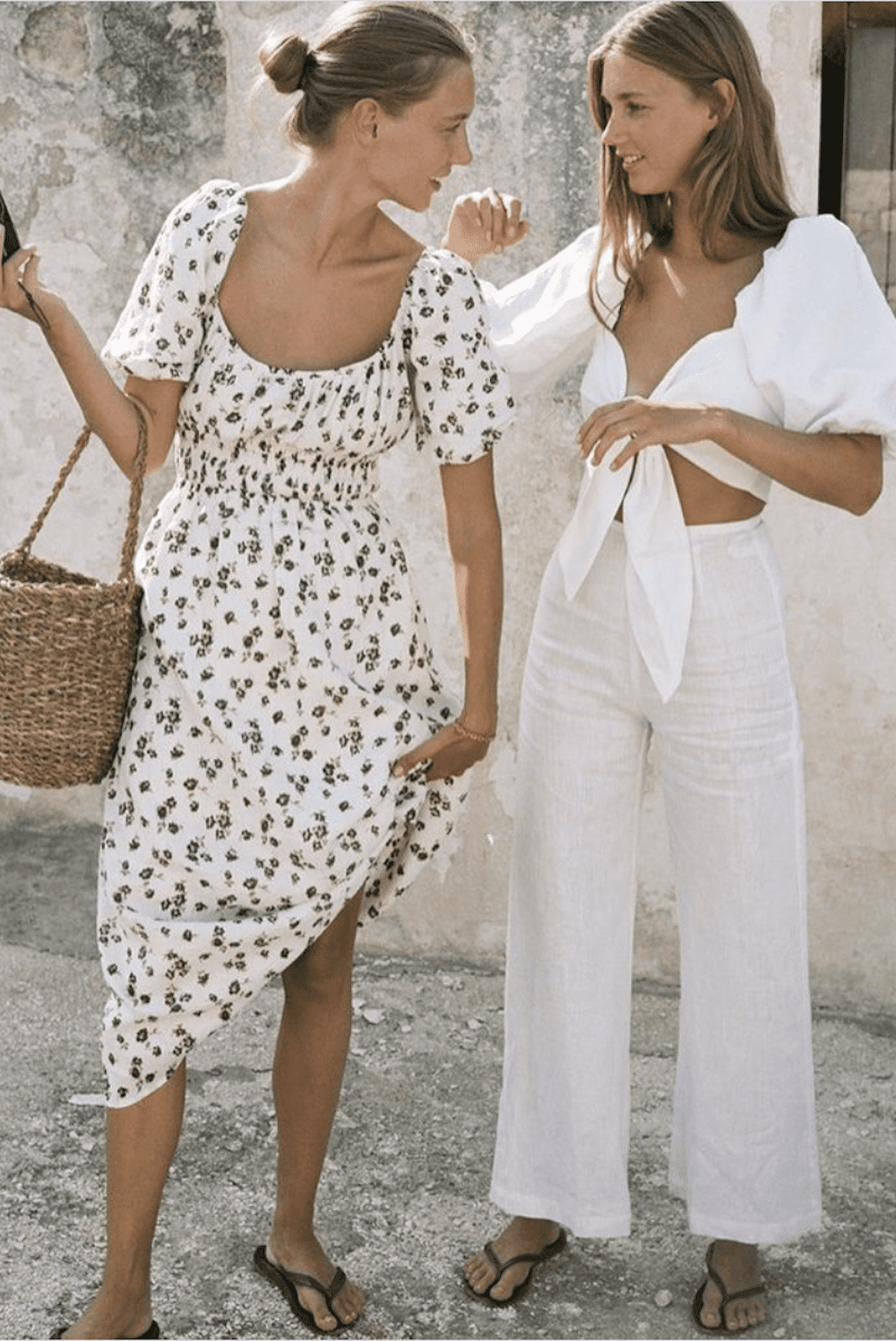 image of two women taking to each other wearing a floral dress and white linen matching pant suit