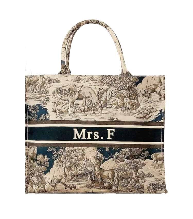 image of a canvas tote bag with a nature print embroidery in black and white and personalization horizontal strip