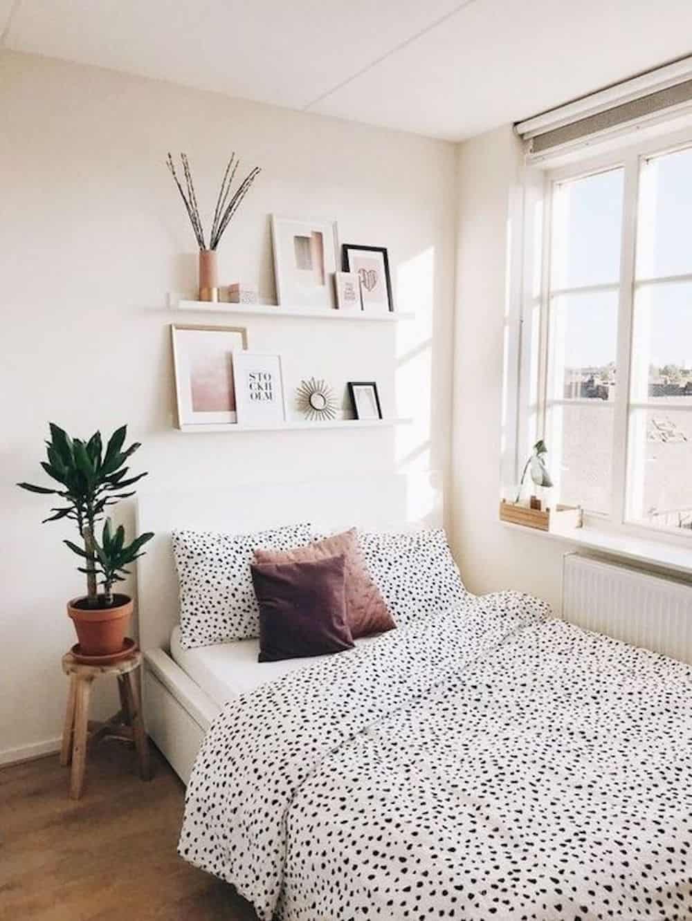 image of a white bedroom with a small bed with a white and black dot duvet cover and minimal decor