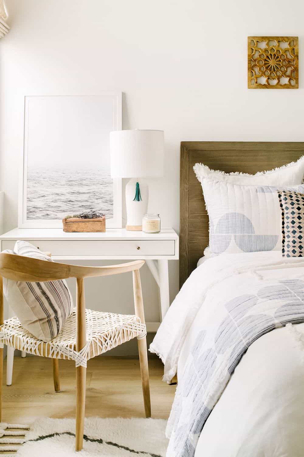 image of a serene bedroom with minimal color tones and a white desk with brown wooden chair