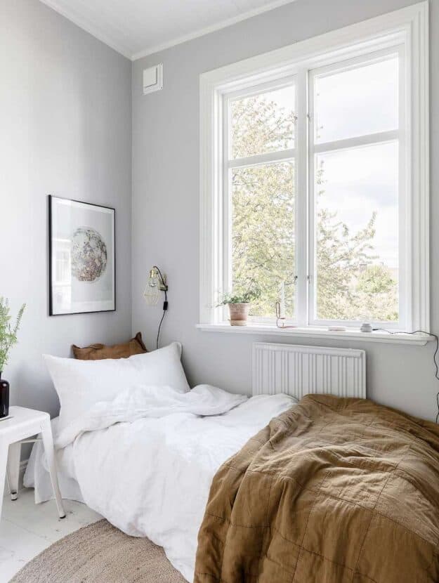 image of a bedroom with a small white bed and minimalist decor