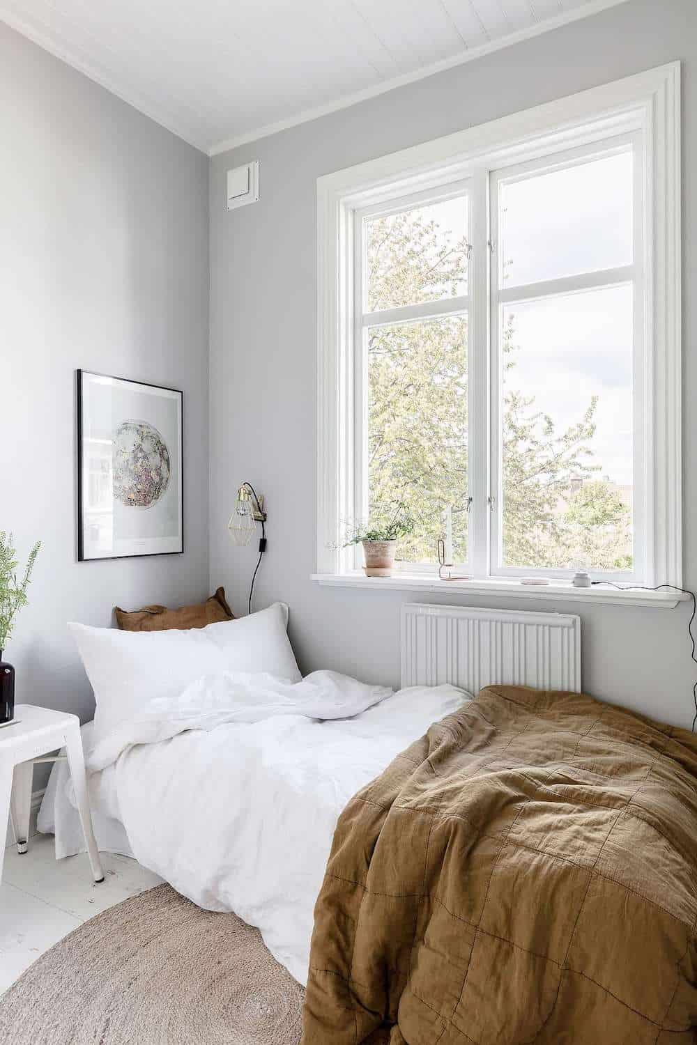 image of a bedroom with a small white bed and minimalist decor