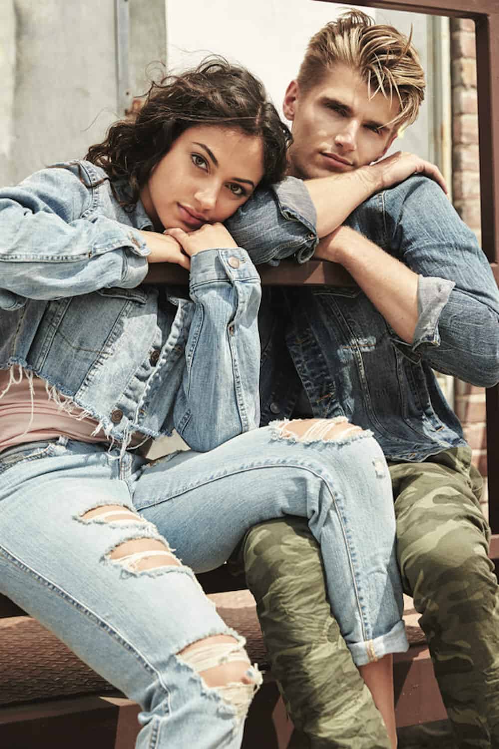 image of a guy and a girl both wearing denim jackets leaning against each other