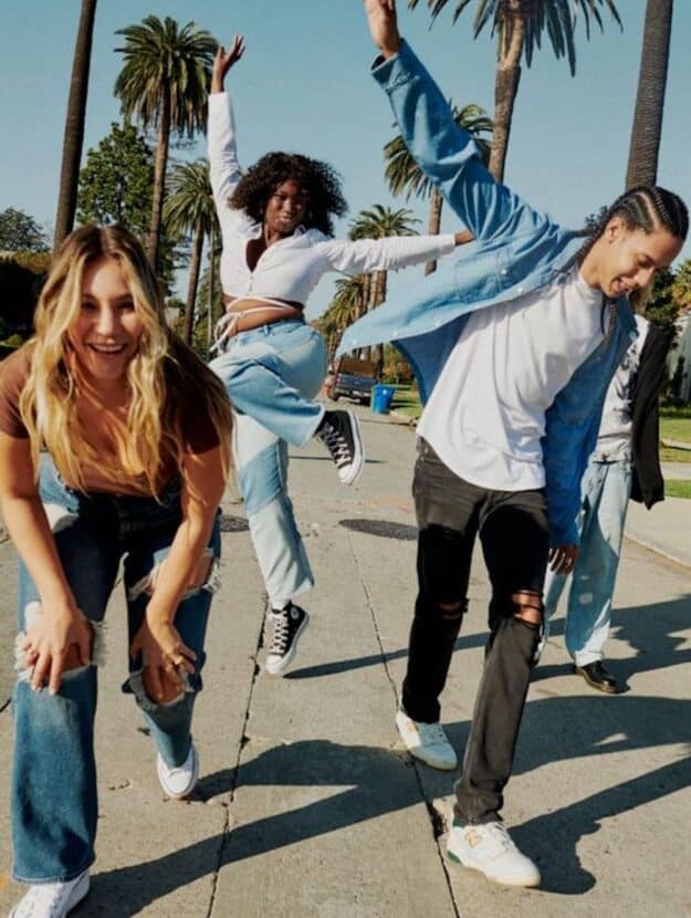 image of a group of teenagers dancing along the sidewalk in trendy clothing