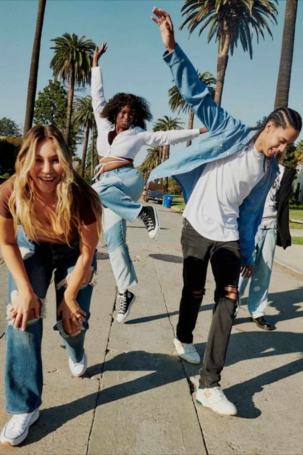 image of a group of teenagers dancing along the sidewalk in trendy clothing