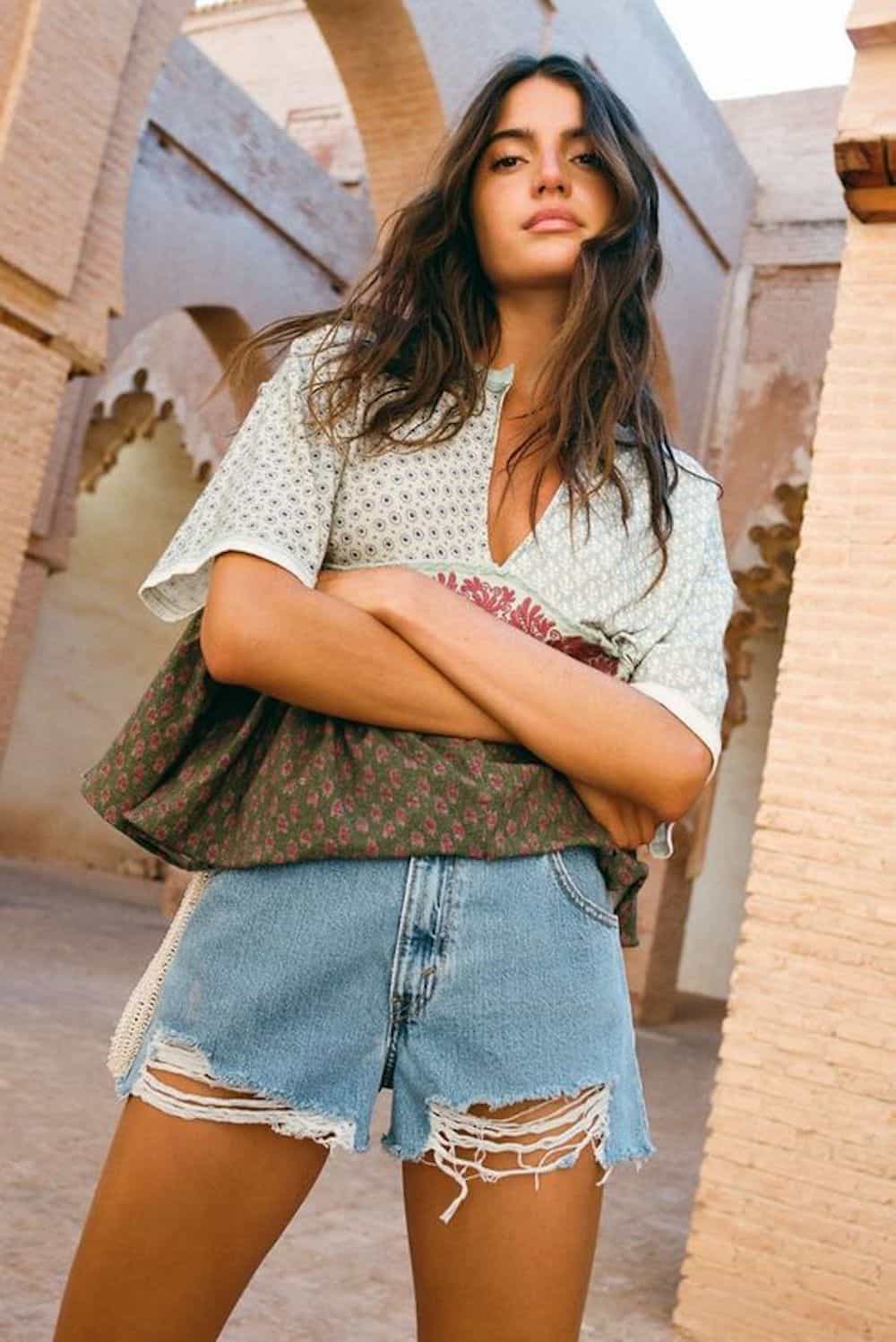 vintage filtered image of a woman wearing a floral top and denim shorts