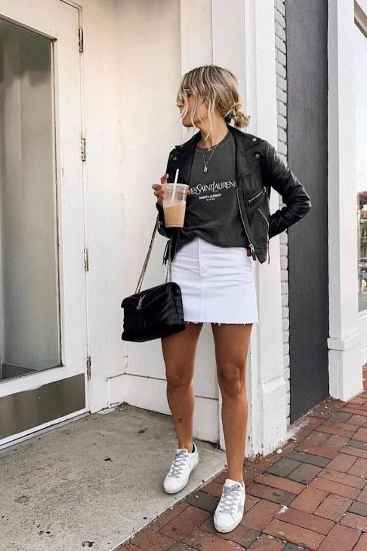 image of a woman in a white jean skirt, black leather jacket, white sneakers, and a designer black purse