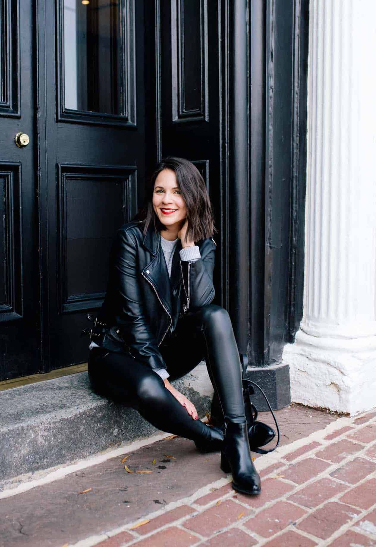 image of a woman sitting on a step wearing leather leggings, black boots, and a black leather jacket