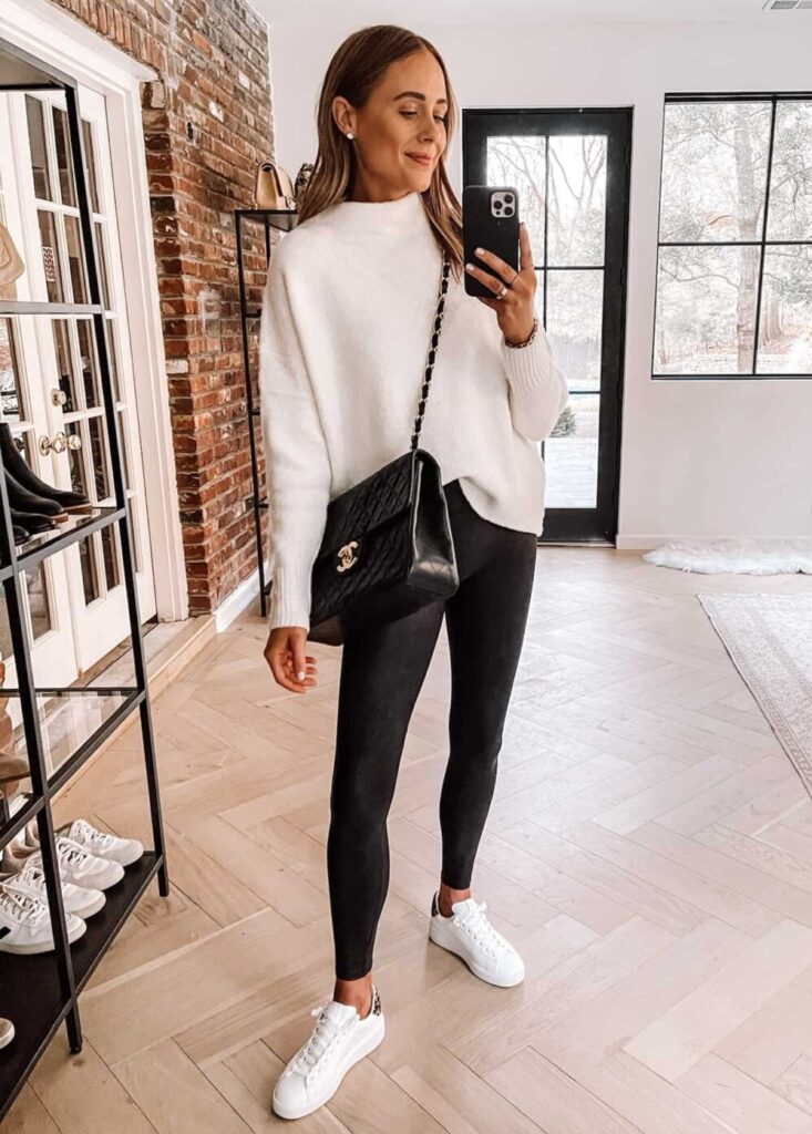 woman wearing a white sweater with leather leggings and white sneakers