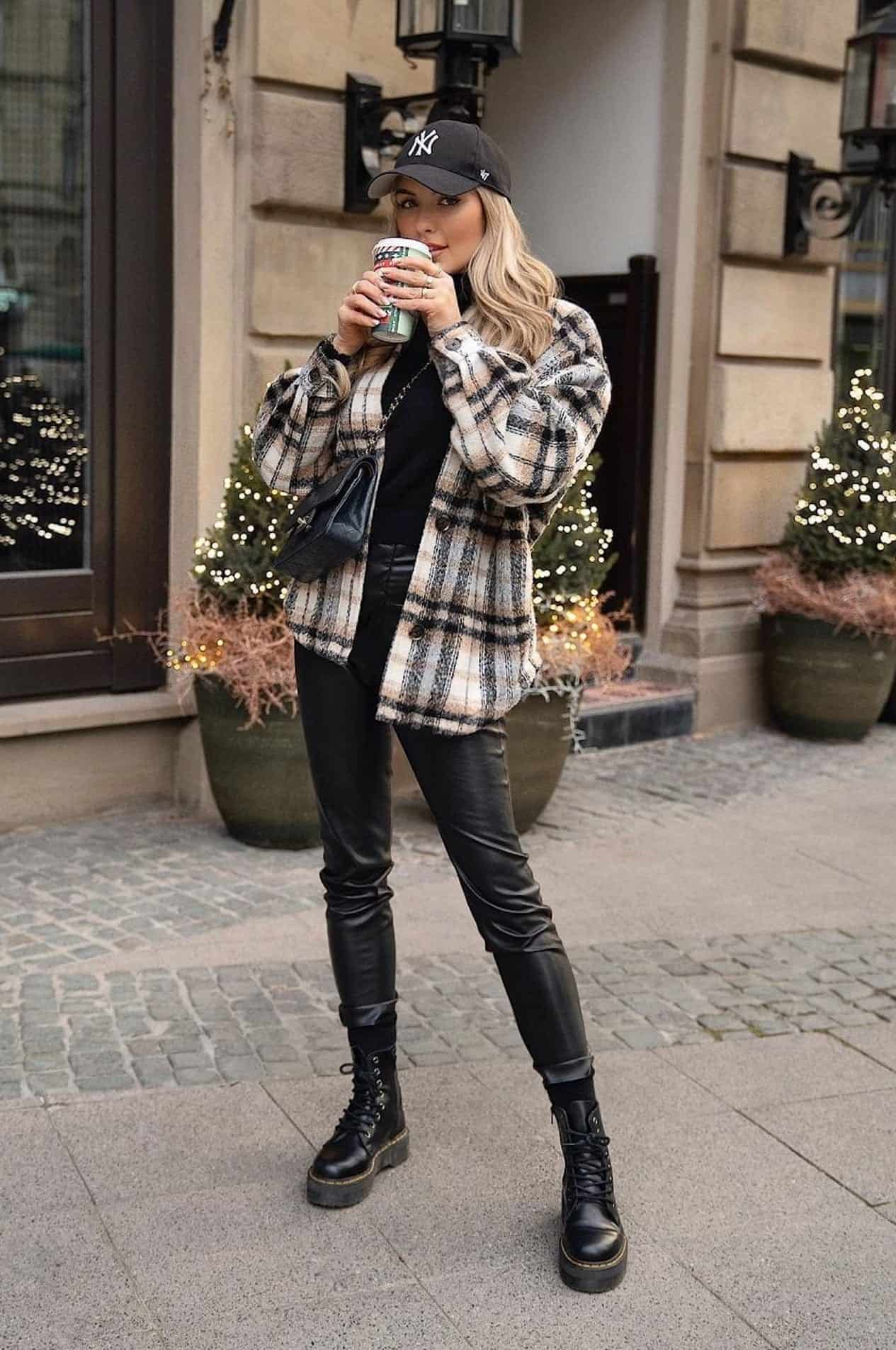 image of a woman in a plaid shirt jacket, black leather leggings, and black combat boots