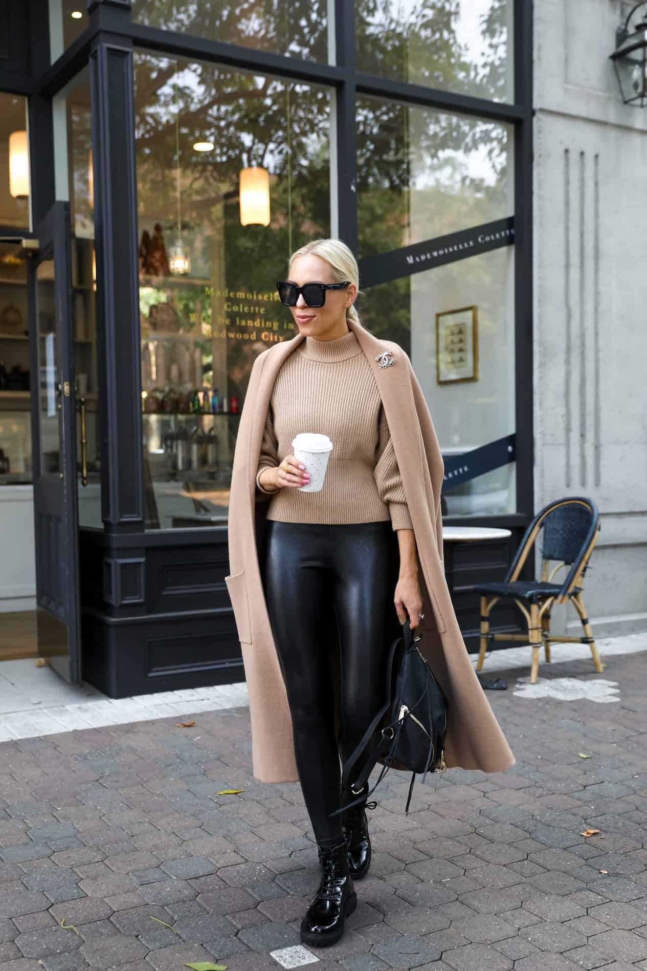 image of a woman wearing a camel wool coat, camel knit sweater, and black leather leggings with combat boots