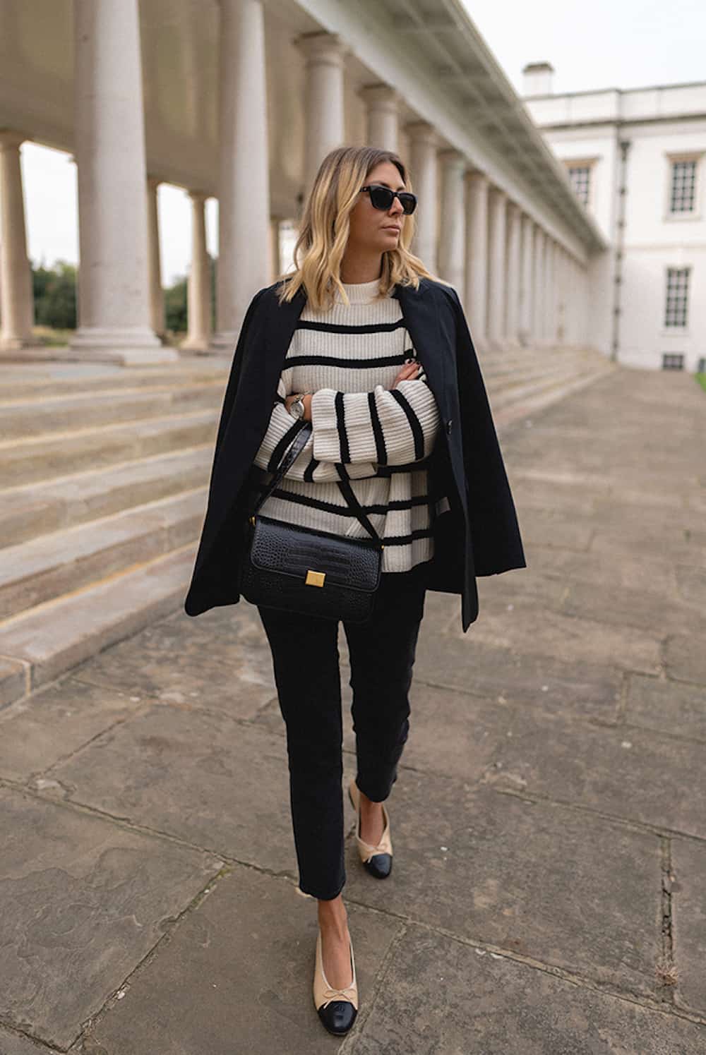 image of a woman in a striped sweater, black blazer, black pants, and cap-toe heels