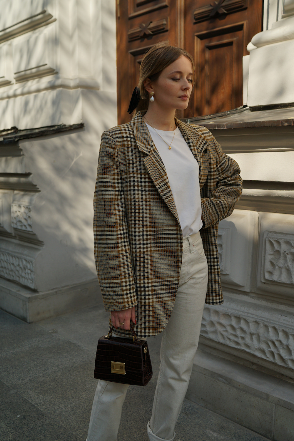 image of a woman in a plaid blazer, white t-shirt, and white jeans